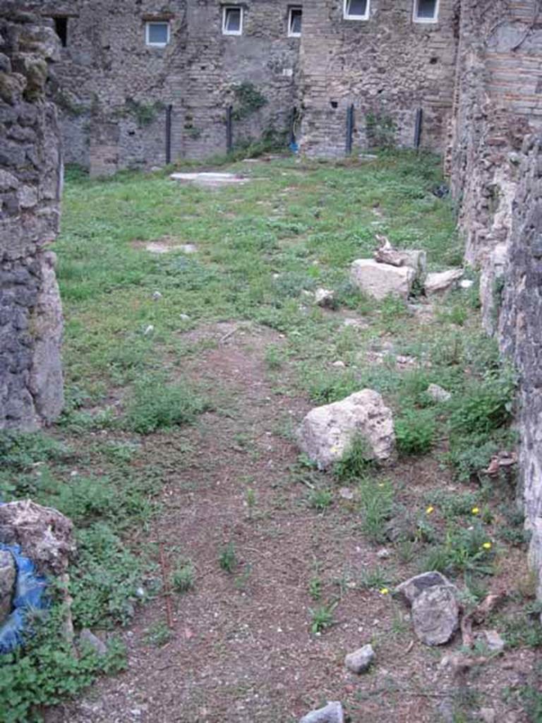 VIII.7.10 Pompeii. September 2010. Looking west from kitchen across garden, linked to VIII.7.6 and VIII.7.11.
In the upper centre, near the modern wall, would have been the latrine.
In this garden, near the south wall, there would have been another triclinium that had a pergola in antiquity.
Photo courtesy of Drew Baker. 
Site of kitchen, described by Eschebach as having hearth, well and lararium.
See Eschebach, L., 1993. Gebäudeverzeichnis und Stadtplan der antiken Stadt Pompeji. Köln: Böhlau. (p. 389)
According to Boyce, in the wall of the kitchen there was a niche and beside it was a lararium painting.
It represented a sacrificial scene with the Genius and the tibicen, one on each side of an altar.
On either side of them was a Lar. In the lower zone was a single serpent beside an altar.
See Boyce G. K., 1937. Corpus of the Lararia of Pompeii. Rome: MAAR 14. (p.78, no.377).
See Sogliano, A., 1879. Le pitture murali campane scoverte negli anni 1867-79. Napoli: (p.12, no.24, “badly preserved”).
According to Mau  -
“Next to the hearth there was the usual painting of the Lares, and a niche.”
See Mau in BdI, 1875, (p.166 - La quarta casa). 

