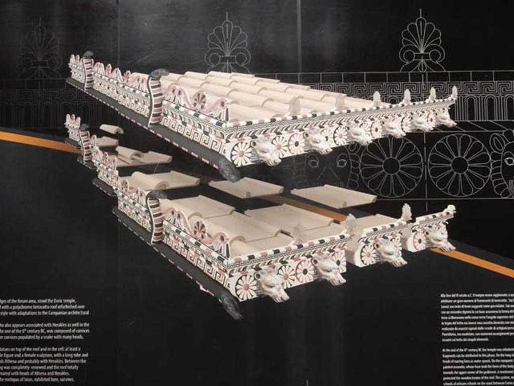 VIII.7.31 Pompeii, May 2018. Roof reconstruction drawing from information notice-board. 
On the long side ran a cornice (sima) with the heads of roaring lions as waterspouts.
On the ramparts was a flat band with a painted meander whose base took the form of the body of a snake with heads facing towards the upper corner of the pediment.
A revetment plaque with guilloche (an engraved pattern of spirals, intertwining bands etc.) in relief protected the wooden beams of the roof.
Photo courtesy of Buzz Ferebee.
