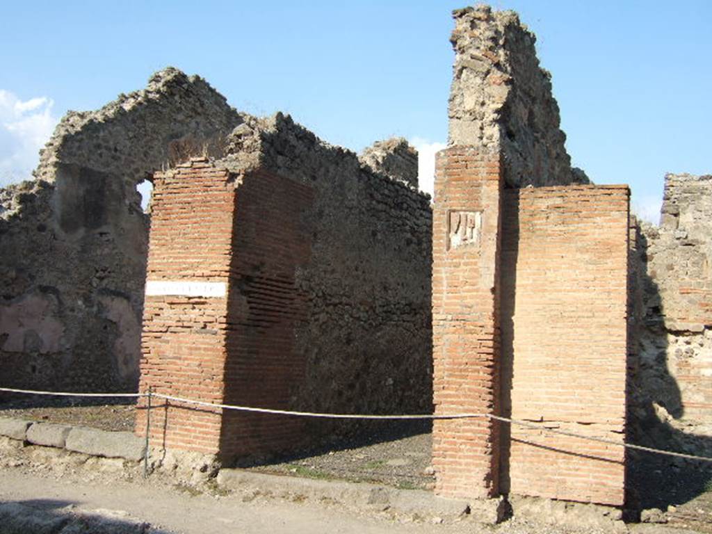 IX.1.5 Pompeii. September 2005. Entrance doorway on Via Stabiana.
The threshold or sill of the doorway was made from blocks of lava.
On the right, (south side) the circular hollow for the door hinge/pivot could be seen.
On the left, (north side) two rectangular hollows for the latch/doorbolt could be seen, as well as an embedded iron bar.
