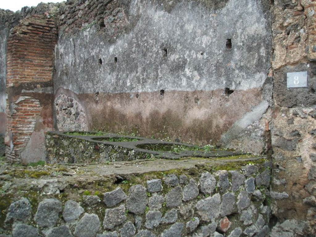 IX.1.8 Pompeii. December 2004. Bar counter and south wall with high purple/dark red zoccolo/plinth topped with a white middle zone.