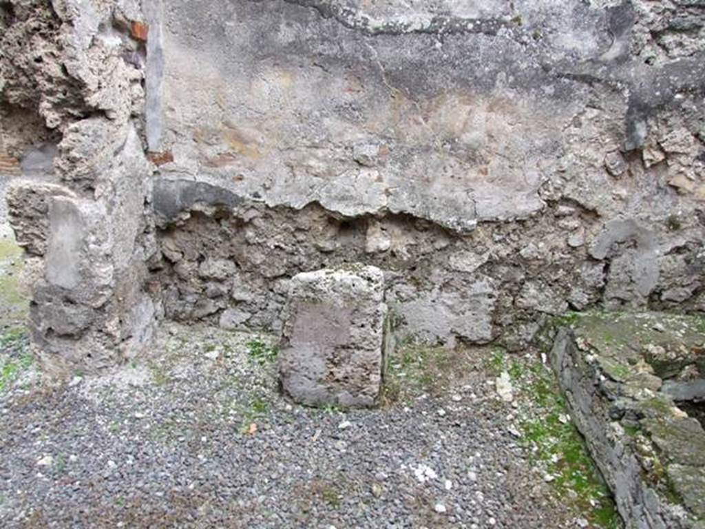 IX.1.12 Pompeii. December 2007. South wall and south-east corner near doorway of kitchen. Masonry altar.   According to Boyce, the lararium painting was done on a white background.
When he wrote his book in 1937, he said that on the right and left, the legs of the figures of the Lares were preserved.
In the middle was the lower part of Venus Pompeiana wearing a yellow chiton and blue mantle.
In her left hand she held a sceptre, and her right rested on a rudder.
At her side was a cupid who seemed to be leaning forward to touch the garment of the goddess.
Below this, the two serpents confronted at a painted altar.
On the floor below the painting a masonry altar stands against the wall.
See Boyce G. K., 1937. Corpus of the Lararia of Pompeii. Rome: MAAR 14. (p.79)    
Remains of the altar and household shrine recorded by Helbig: Kitchen: Venus Pompeiana and Gods, 66?   See Helbig, W., 1868. Wandgemälde der vom Vesuv verschütteten Städte Campaniens. Leipzig: Breitkopf und Härtel. (66). See Pappalardo, U., 2001. La Descrizione di Pompei per Giuseppe Fiorelli (1875). Napoli: Massa Editore. (p.138) See Fiorelli, G. (1875). Descrizione di Pompei, (p.370)


