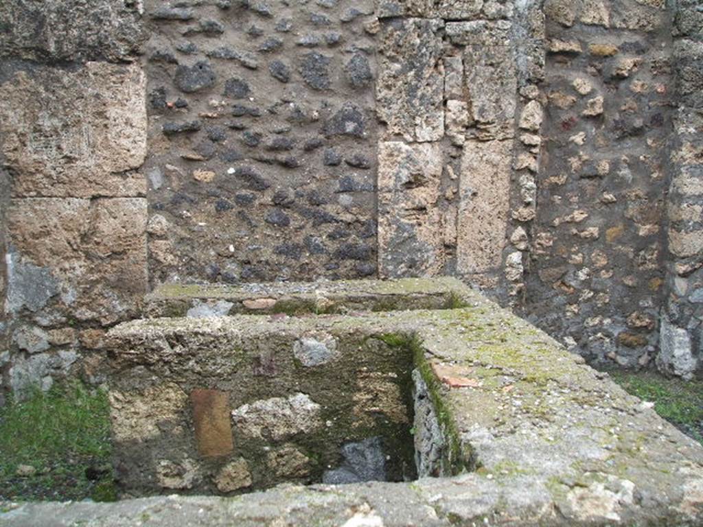 IX.1.13 Pompeii. December 2004. Looking east across counter with remains of hearth on north side of shop-room.