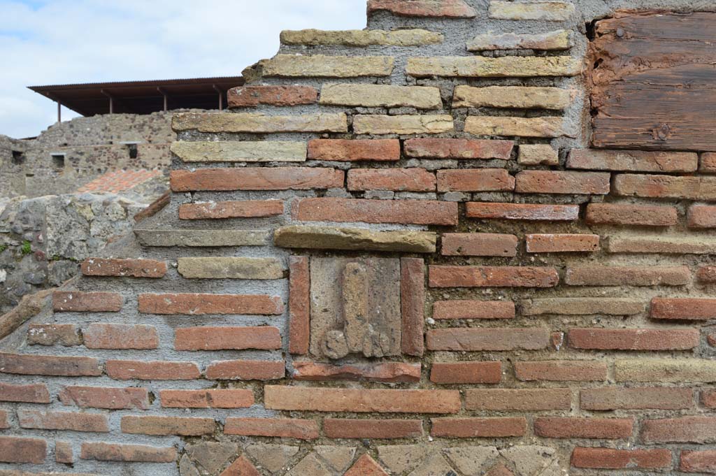 Pilaster between IX.1.13 and IX.1.14 Pompeii. March 2018.  
Detail of tufa phallus set into pilaster between entrances.
Foto Taylor Lauritsen, ERC Grant 681269 DCOR.
