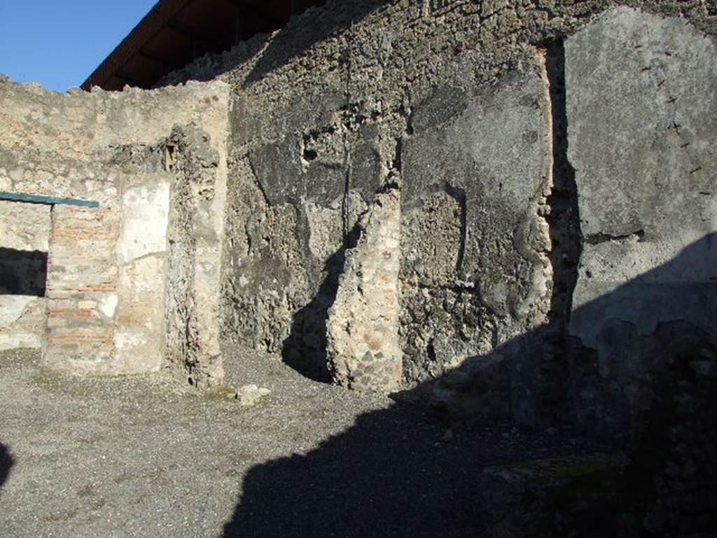 IX.1.18 Pompeii. December 2006. Looking north-east across yard towards site of kitchen, latrine and stairs to upper floor, in shadow. In the middle can be seen the doorway to the storeroom or cupboard.
