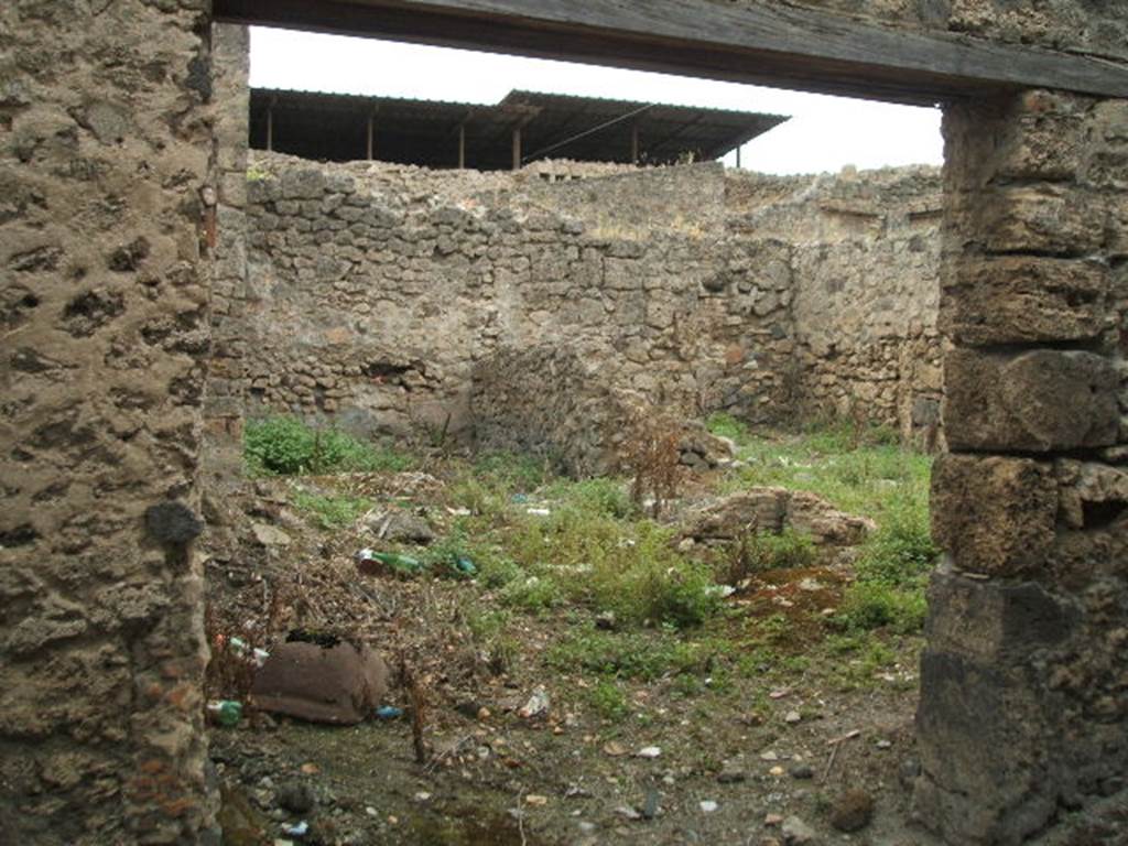 IX.1.28 Pompeii. May 2005. Entrance, looking west towards two rear rooms, and a latrine. 
According to Eschebach, at the rear were two cubicula for grooms and a latrine beneath the stairs to the upper floor. See Eschebach, L., 1993. Gebäudeverzeichnis und Stadtplan der antiken Stadt Pompeji. Köln: Böhlau. (p.
The wall on the right of the entrance doorway used to show the graffito: 
L(ucium)  Albucium  aed(ilem)
Thesmus  libert(us)  rog(at)    [CIL IV 2983]
Della Corte made the comment that probably Thesmus was a freedman of the candidate L. Albucius (Celsus) and he was showing his support in CIL IV 2983.
See Della Corte, M., 1965.  Case ed Abitanti di Pompei. Napoli: Fausto Fiorentino. (p. 212)

