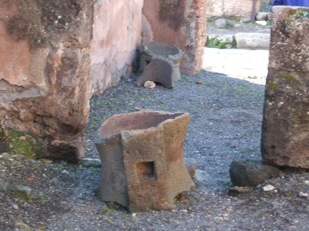 IX.2.4 Pompeii. December 2004. Doorway of triclinium, with fragments of mills, looking west.