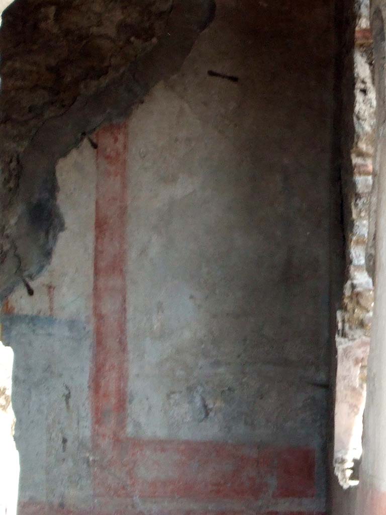 IX.2.7 Pompeii. May 2006.Painted wall in triclinium (k) showing the south end of the east wall.
The red zoccolo showed a panel with oval-leafed plants and compartments with a hanging disc under the separating cornice of the middle zone.
The middle zone presented a white panel, with wide yellow border and a painting of a trophy vase.
The south wall had a window overlooking the garden area.
It was in the centre of the wall between the two white side panels, in which were paintings of trophy vases (13 x 22 - vasi agonistici), now illegible.
The zoccolo was red.
On the west wall, to the north of the doorway, with a yellow central panel and a white predella below it, was a painting with Leda, now illegible. (see Helbig 143).
On the north wall, in the central panel, was a painting of Achilles at Skyros, but preserved only in the upper right corner. (See Helbig 1302).
See Bragantini, de Vos, Badoni, 1986. Pitture e Pavimenti di Pompei, Parte 3. Rome: ICCD. (p.409)
See Helbig, W., 1868. Wandgemälde der vom Vesuv verschütteten Städte Campaniens. Leipzig: Breitkopf und Härtel. (143 and 1302)
