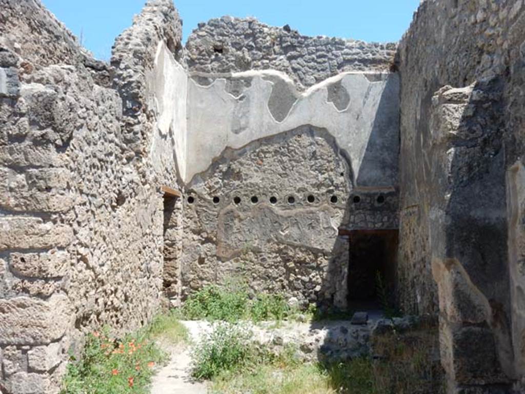 IX.2.27 Pompeii. May 2017. Looking east across room in south-east corner, with doorway to another room at the rear, on the right.  On the left is a doorway leading to the area under the stairs. Photo courtesy of Buzz Ferebee.

 
