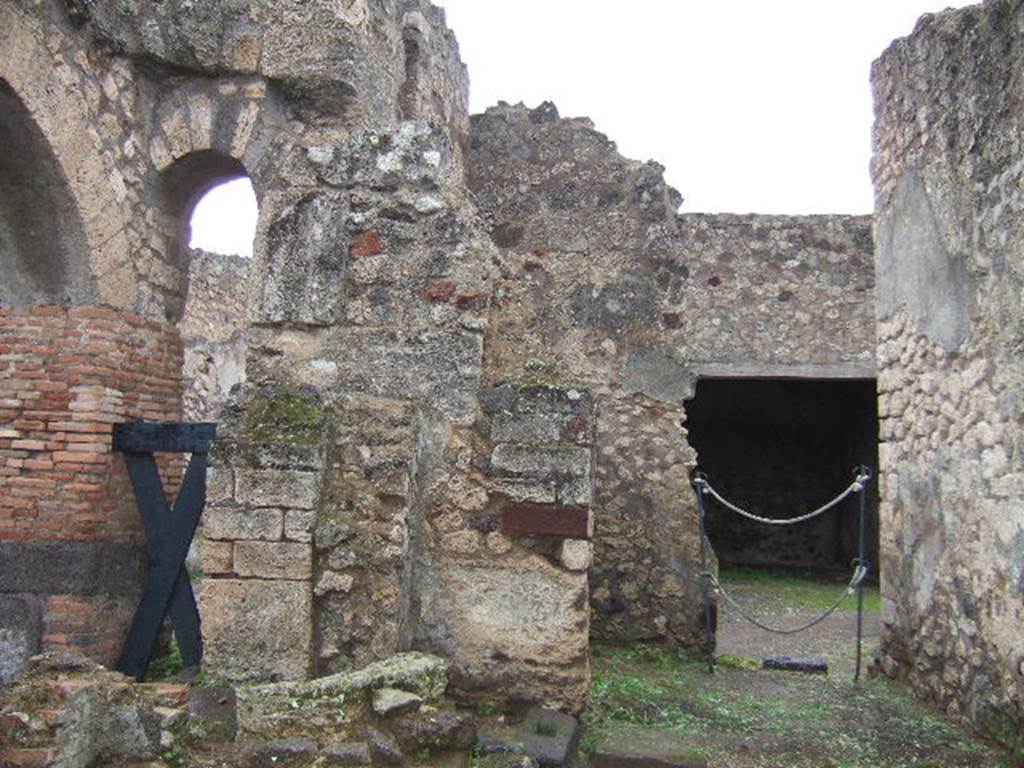 IX.2.28 Pompeii. December 2005. Looking east from IX.2.1, towards kitchen, latrine and storeroom, and through doorway to porticus of IX.2.27.
