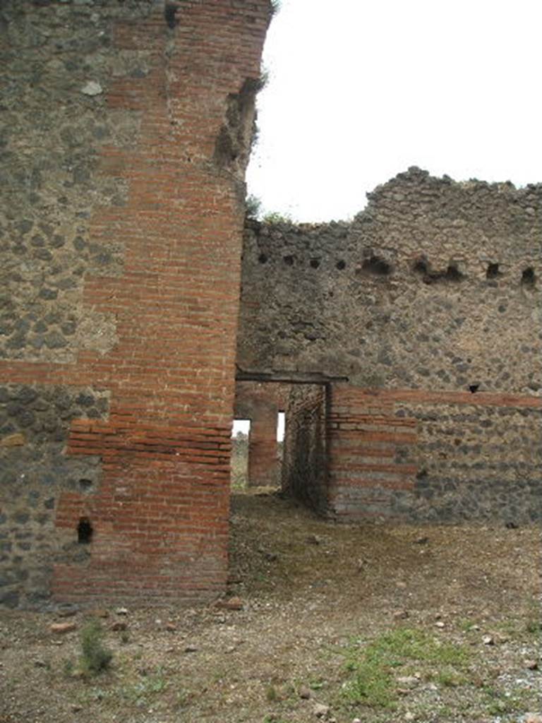 IX.4.16 Pompeii. May 2005. Looking west from entrance across the open area u, described by Mau, towards the corridor leading into the area i which may have been a changing room. The doorway at the far end would have led to the palaestra [d].