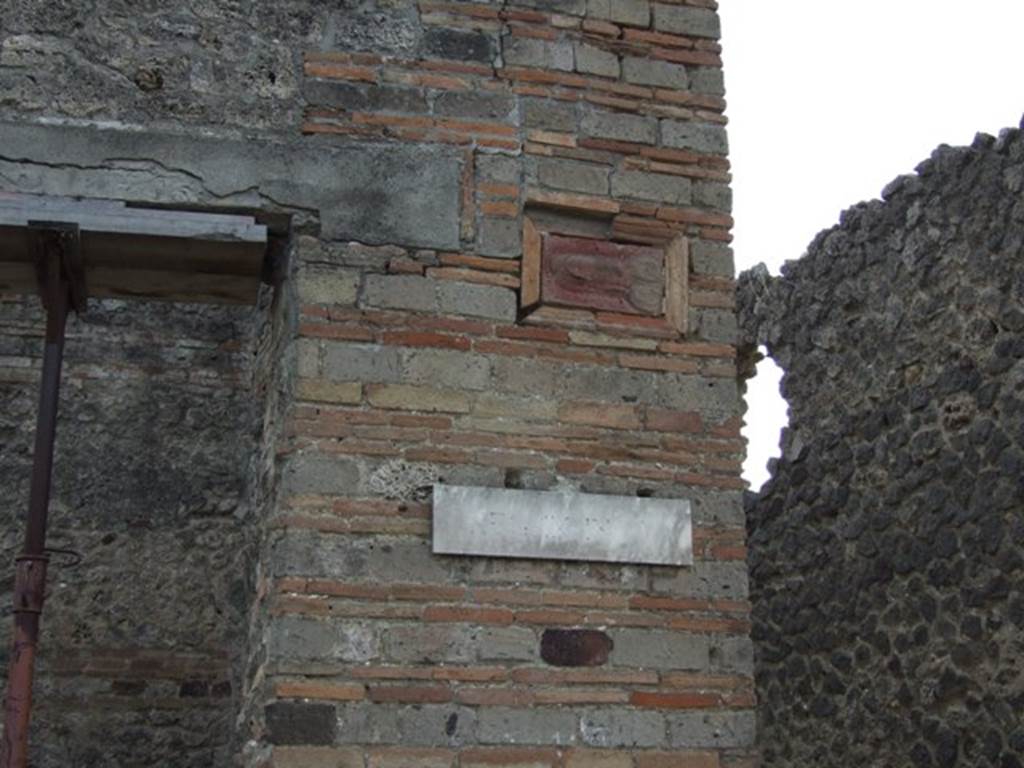 IX.5.1 Pompeii. May 2005. Terracotta wall plaque of phallus, on wall on west side of entrance, outside IX.5.1.