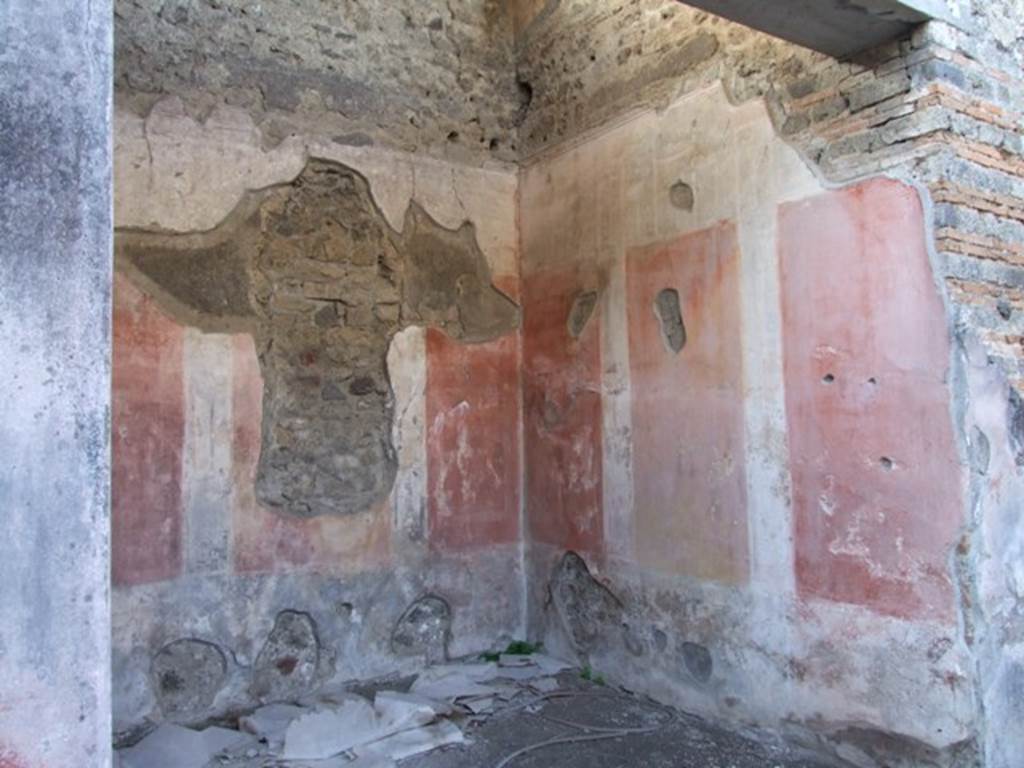 IX.5.11 Pompeii. December 2007. Room 8, ala, on west side of atrium, north-west corner.
According to Bragantini, the lower plinth and zoccolo of the walls in the ala were black. The zoccolo was divided into panels with hanging garlands separated by narrow compartments with painted plants. The middle zone of the walls contained a yellow central panel, and red side panels. On the north and south walls, each panel contained a painted medallion. On the west wall, the side panels contained a vignette of a cupid. The upper zone of the walls was white.
See Bragantini, de Vos, Badoni, 1986. Pitture e Pavimenti di Pompei, Parte 3. Rome: ICCD. (p.472, ala e)
