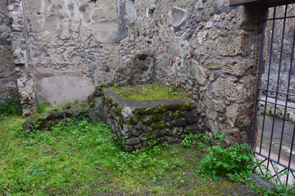 IX.5.11 Pompeii. March 2017. Room r, looking north-east towards hearth, with doorway at IX.5.13, on right. 
Foto Christian Beck, ERC Grant 681269 DÉCOR.
According to Boyce –
In the kitchen entered from the east side of the peristyle and having separate communication with the street at IX.5.13, in the north wall is a rectangular niche (h.0.40, w.0.45, d.0.20, h. above floor 0.95), and on the wall beside it are faint traces of the original lararium painting.
He gives the reference - Bull. Inst. 1879, p.195, which says - .
“Fra l’ingresso e il focolare evvi nel muro nord la nicchia de’Lari e deboli tracce della pittura lararia”.
(Between the entrance and the hearth, there is in the north wall faint traces of the niche of the Lares and lararium painting).
See Boyce G. K., 1937. Corpus of the Lararia of Pompeii. Rome: MAAR 14. (p.86, no.424).
(Note: it looks like the north wall at rear of the hearth has fallen).




