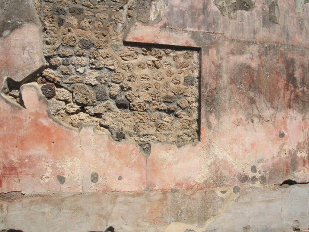 IX.5.14 Pompeii. May 2005. Room f, north wall of triclinium with painting cut from it.
In the black zoccolo were panels with squares alternating with narrow compartments with painted plants: 
Seen in the side panels of the red middle zone of the wall, were vignettes with painted Muses, (but badly preserved). 
In the centre would have been a painting with a scene of uncertain identification, possibly Dido receiving Aeneas for the first time.
