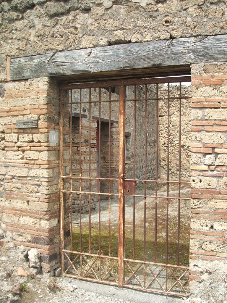 IX.5.16 Pompeii. May 2005. Entrance doorway.
An inscription was found on the outside wall, it read –

Optata
verna a(ssibus) II    [CIL IV 5105]

This translates as “Optata sells herself for 2 asses”   [CIL IV 5105]
See Varone, A., 2002. Erotica Pompeiana: Love Inscriptions on the Walls of Pompeii, Rome: L’Erma di Bretschneider. (p.144, note 243)
