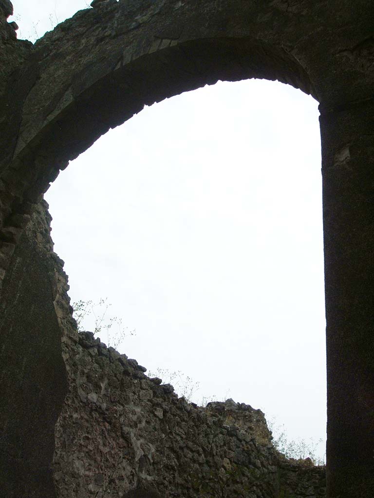 IX.5.22 Pompeii. May 2005. Looking south-east through doorway towards high arched entrance to kitchen. 
This can also be seen in IX.5.2, pt.4, room ‘s’.

