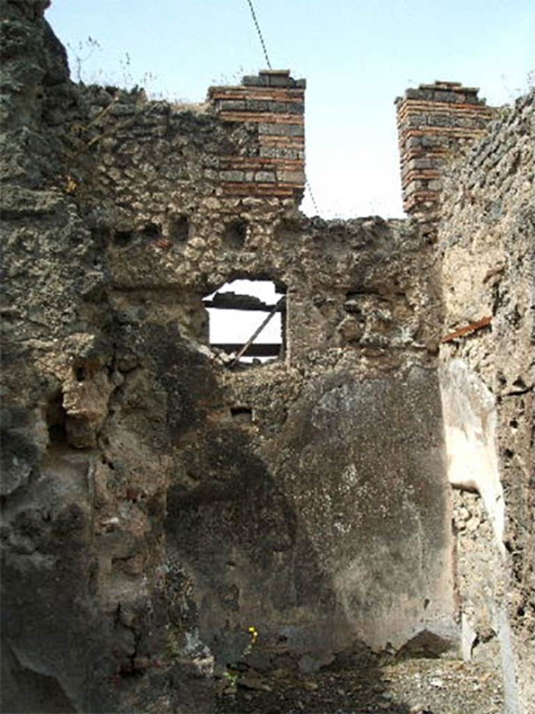 IX.6.3 Pompeii. May 2005. 
Room “m” to south of entrance corridor, with window in west wall onto Vicolo di Tesmo.
According to Mau, room "m" had a wooden threshold, the jambs of the entrance were furnished with door-frames. 
The floor, a type of opus signinum, was decorated with stars and in the centre, with a square-shaped ornament, simple but with good effect, all made from white stones.
The plaster of the walls showed a rough decoration with a white background in the IV style:  
Originally in the centre of each wall had been a flying cupid; 
• the one on the right carried a thyrsus and crown, 
• that to the rear a thyrsus and a helmet on its left, 
• the one on the left carried a shepherd’s crook and an unrecognizable object.
In the south-west, a narrow doorway gave passage to room "L". 
The threshold was exceedingly high and had the appearance of having been the first step of a staircase, which maybe first gave access to the upper floor before the stairs were built in room "i". 
See Mau in BdI, 1880, p.220-1.
