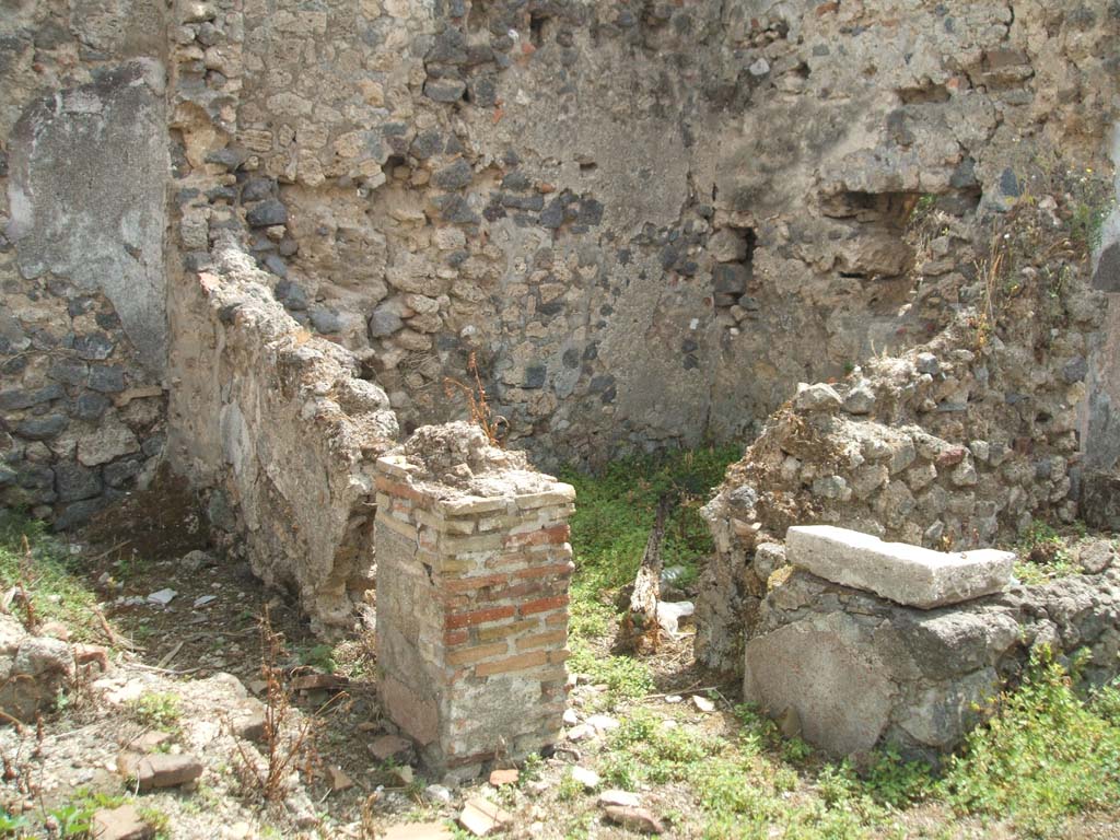 IX.6.7 Pompeii. May 2005. Looking south-east to two rooms on east side of entrance.
These would have been a latrine room “q” on left, and small room or storeroom room “r”, on right.
The remains of the tub/basin can be seen on the right of the photo.
