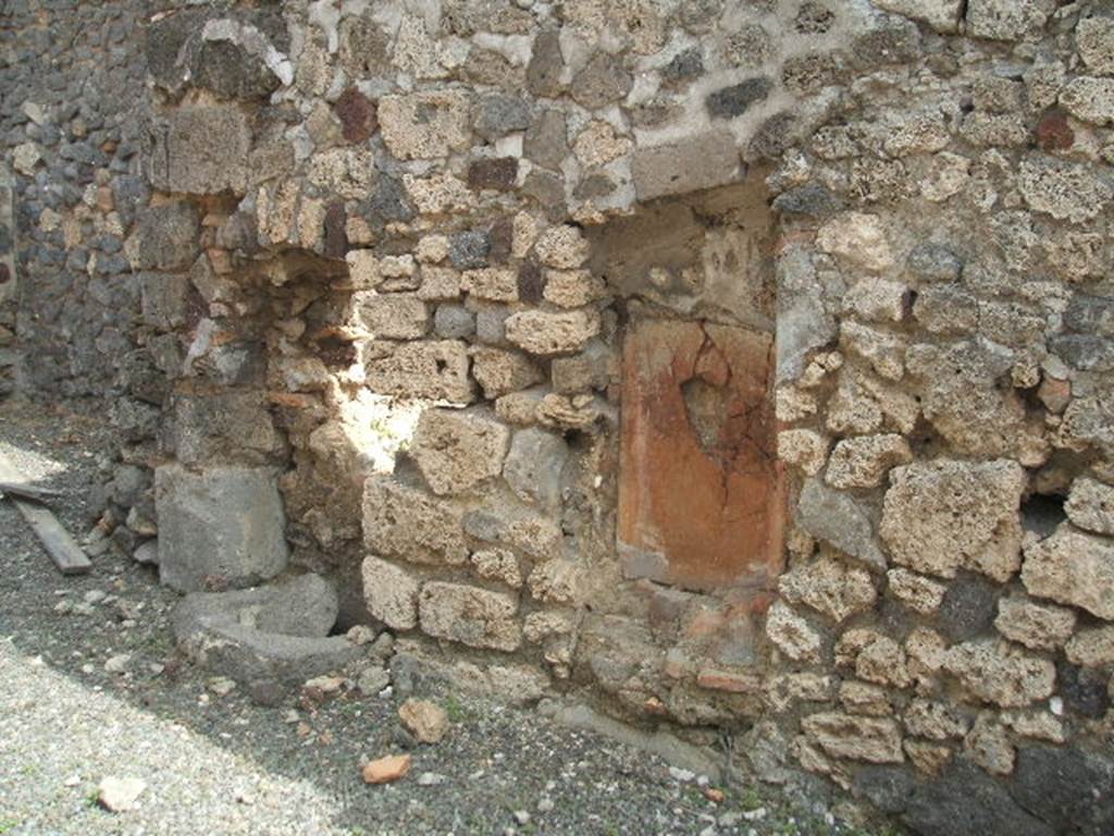 IX.6.b Pompeii. May 2005. East wall of middle room at rear of bar, described by Mau as the kitchen. On the right (east) side of the kitchen, according to Mau, was firstly the hearth followed by the cistern made from of lavastone without a puteal. On the left side, firstly was the latrine (in a vaulted niche) and a water-pipe from the upper floor, followed by the first step of the stairs that led up the left wall of the last room, leading up to the upper floor. 
See also Mau in BdI 1881, (p.30-1)
