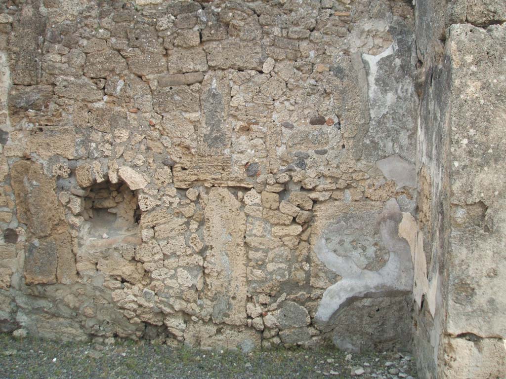 IX.6.e Pompeii. May 2005. Niche on east wall.
According to Boyce, in the east wall of the taberna was a niche with peaked ceiling.
Its walls were coated with white stucco outlined in red.
Around it on the wall was a lararium painting, of which only a cornucopia on the left side could be seen when excavated. 
See Boyce G. K., 1937. Corpus of the Lararia of Pompeii. Rome: MAAR 14. (p.87, no.433) 
According to Sogliano, in the shop a sacred picture was found. 
See Notizie degli Scavi di Antichità, 1879, p. 72.
See Sogliano, A., 1879. Le pitture murali campane scoverte negli anni 1867-79. Napoli: (p. 19, no. 71).
