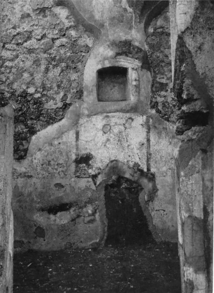 IX.6.g Pompeii. Niche set into west wall of room in north-west corner of peristyle.
According to Boyce, in a small room in the north-west corner of the peristyle, in the middle of the west wall was an arched niche.
Its size – h.0.32, w.0.31, d.0.15, height above floor 1.42.
This was adorned with an aedicula façade of half-columns on each side supporting a cornice.
The cornice ran around the curve of the arch instead of a pediment.
The lower half of each column was red, the upper half white
This inside walls of the niche were decorated with many small irregular blotches of red on a white background.
See Bullettino dell’Instituto di Corrispondenza Archeologica (DAIR), 1881, p. 23.
See Boyce G. K., 1937. Corpus of the Lararia of Pompeii. Rome: MAAR 14. (p. 87, no.435 and Pl.3, 6).

