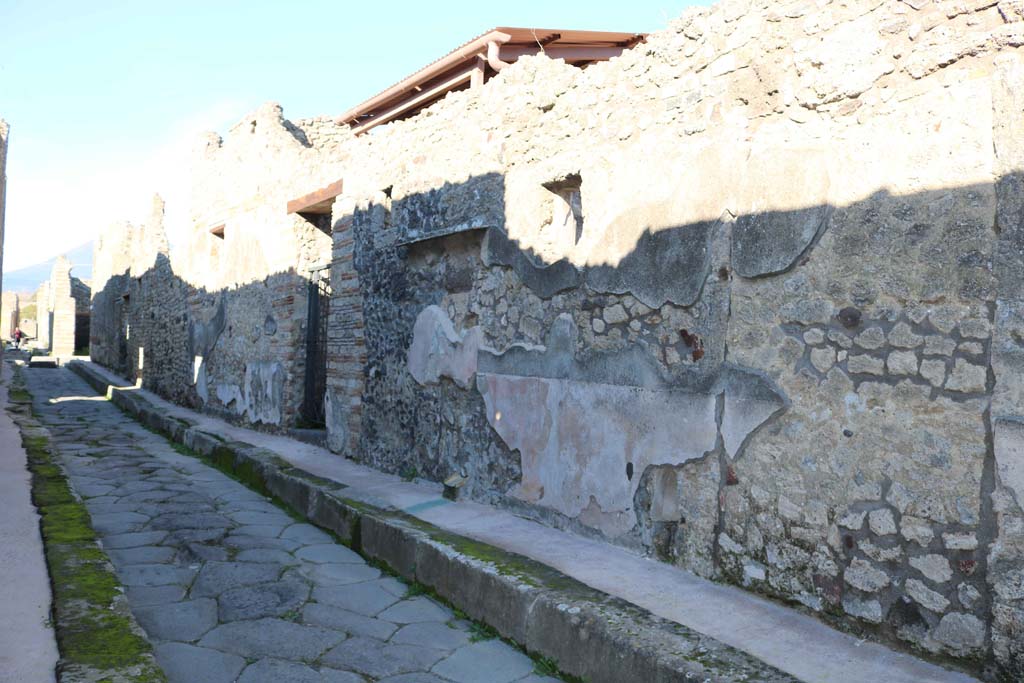 Vicolo di Tesmo looking north past remaining painted plaster on walls outside IX.7.20. December 2018. Photo courtesy of Aude Durand.