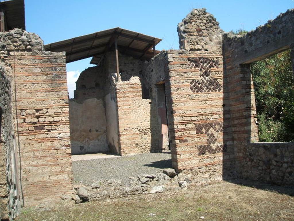 IX.7.20 Pompeii. May 2005. 
Looking north across atrium to ala or triclinium (room e) from large room (k).
Room (k) was possibly a workshop, with window onto west portico of peristyle.
