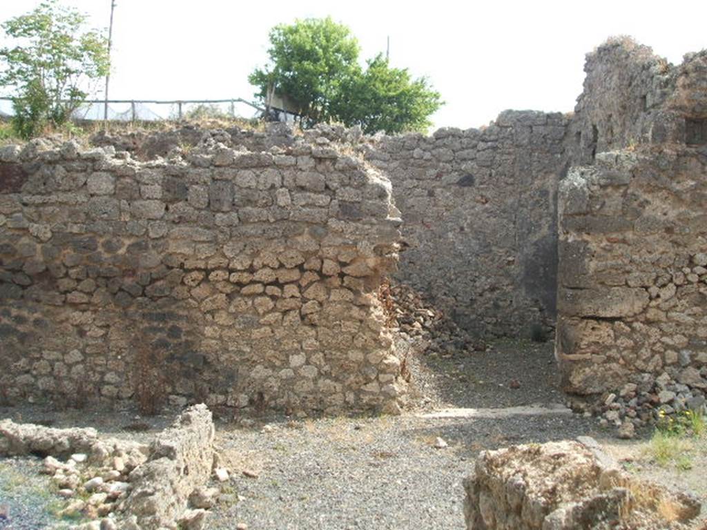 IX.7.21 Pompeii. May 2005. Looking east across atrium to doorway to room, according to Mau possibly used as a dining room. Leaning against the east wall of the atrium would have been the stairs leading to the rooms on the upper floor, above the north-east corner of the atrium. Under the stairs in the north-east corner would have been a storage area or cupboard. In the lower left corner of the photo, can be seen the remains of the pluteus from around the impluvium. The four brick pilasters of the Corinthian atrium are now vanished. See Mau in BdI, 1882, (p.184)

