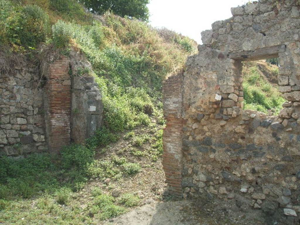 IX.7.26 Pompeii. May 2005. Looking south from end of small roadway towards entrance and room (d).  According to Della Corte, this hostelry had an annexed room for its clients.  He also deduced from the electoral recommendation written in the middle of the external wall between IX.7.26 and 25, the names of the two Pompeians that managed these two premises  -   Fabius Memor cum (Fabio) Celere rogat     [CIL IV 3841, although DC showed it as 3481).  See Della Corte, M., 1965.  Case ed Abitanti di Pompei. Napoli: Fausto Fiorentino. (p.197)
According to Epigraphik-Datenbank Clauss/Slaby (See www.manfredclauss.de),  it read -
Herennium
Celsum  aed(ilem)  o(ro)  v(os)  f(aciatis)
Fabius  Memor  cum  Celere         [CIL IV 3841]

