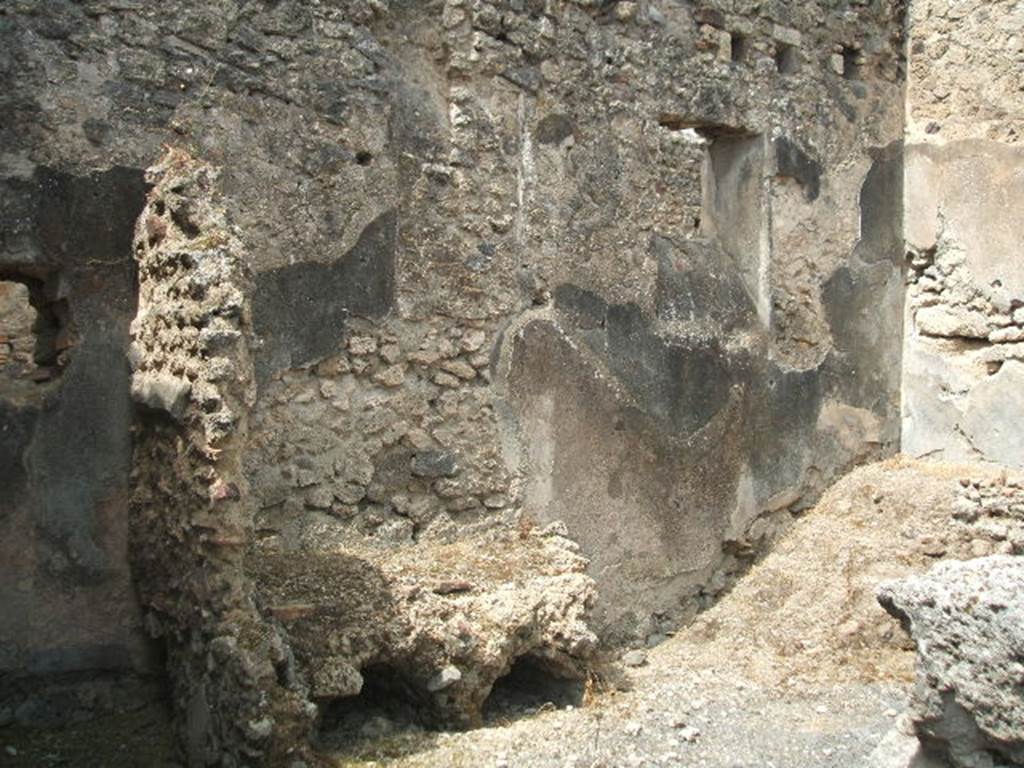 IX.8.b Pompeii. May 2005. Looking west through doorway to kitchen and latrine, towards remains of hearth. The remains of stairs to the upper floor can be seen on the right.
