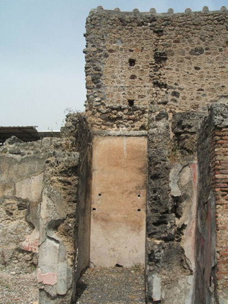 IX.8.b Pompeii. May 2005. Looking north into small room or cupboard in north-east corner of atrium. The north wall shows holes for the supports of shelving.
