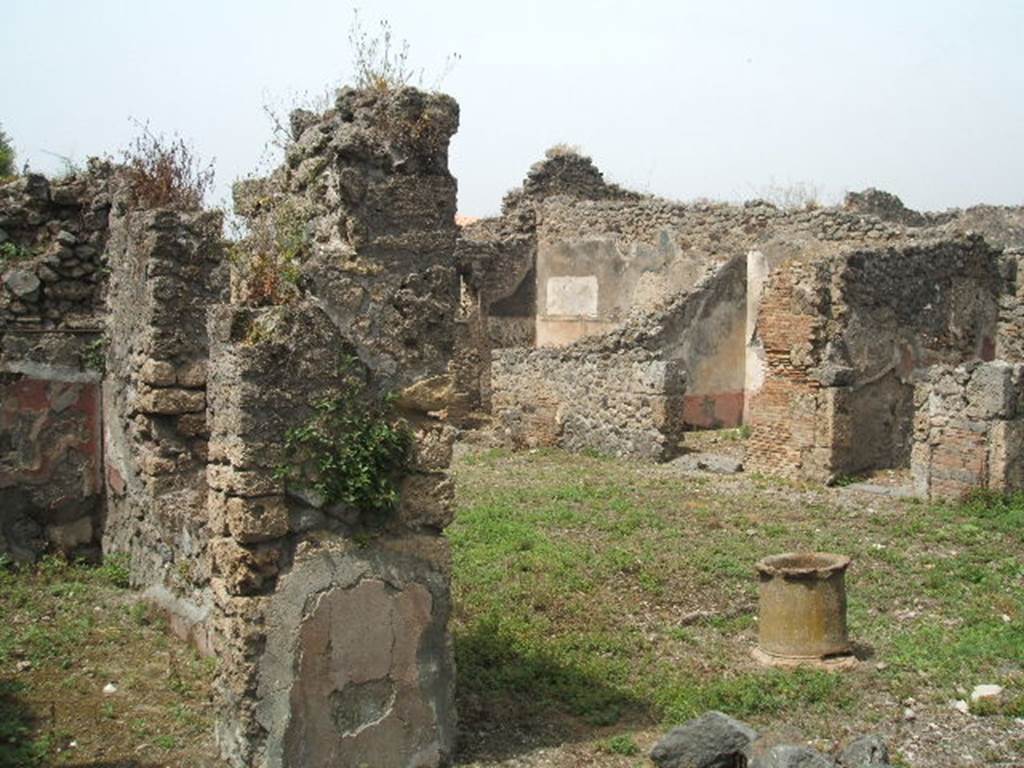 IX.8.c Pompeii. May 2005.  Doorway to room on south side of garden area, on left. Looking north west across peristyle with terracotta puteal, towards rooms on north side.