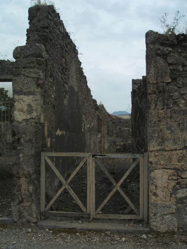 IX.9.2 Pompeii. May 2005. Entrance doorway with long entrance corridor, looking south.
The walls of the corridor were described as being “faced with rough plaster, and on the left wall graffiti could be seen”. See Notizie degli Scavi, 1888, p.514.
