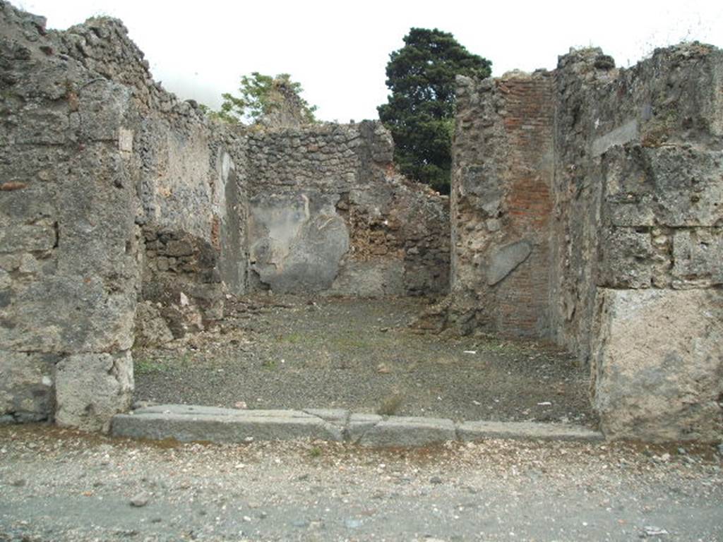 IX.9.7 Pompeii. May 2005. Entrance doorway, looking south towards rear room. According to NdS, this shop communicated with the entrance corridor of the adjacent house (on the right). The rear room had walls with white decoration, and a window which was found destroyed in the pilaster to the right of the entrance room. On this pilaster, in the front shop-room, a series of vertical and parallel lines traced with charcoal were found, which were undoubtedly accounts. It was likely that here in this shop, the vinarius (vintner) owner or tenant of the adjacent house, sold his wines, and in fact, five amphorae were found (see NdS, 1888, p.523)
See Notizie degli Scavi, 1889, p.126.
