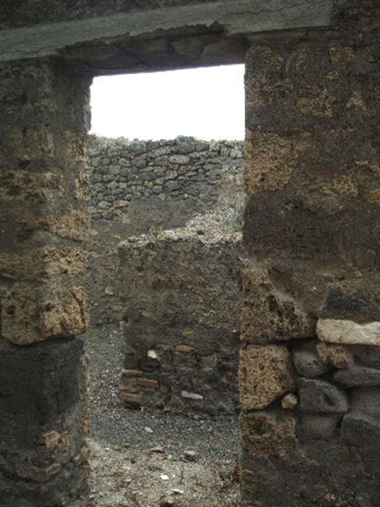 IX.9.9 Pompeii. May 2005. Entrance doorway, looking west. According to NdS, this doorway led into a corridor at the rear of the bar-room of IX.9.8. The corridor contained the latrine, a narrow store-room and the stairs to the upper mezzanine.
