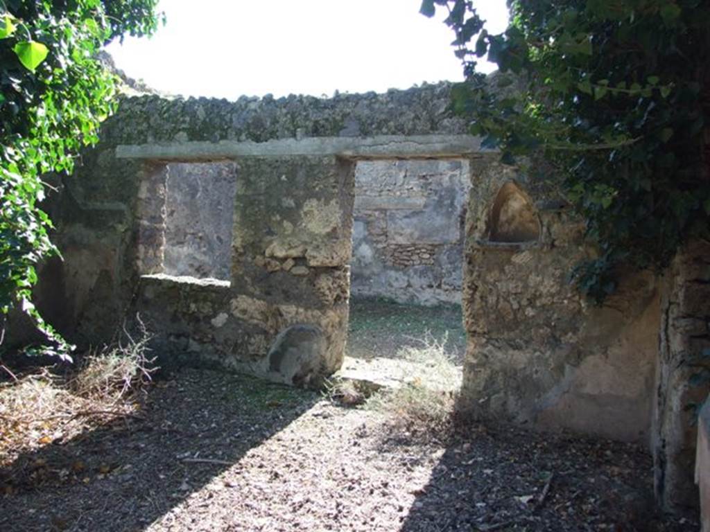 IX.9.11 Pompeii.  March 2009.  Niche on west wall of atrium, with doorway and window to Room 6, Garden. 