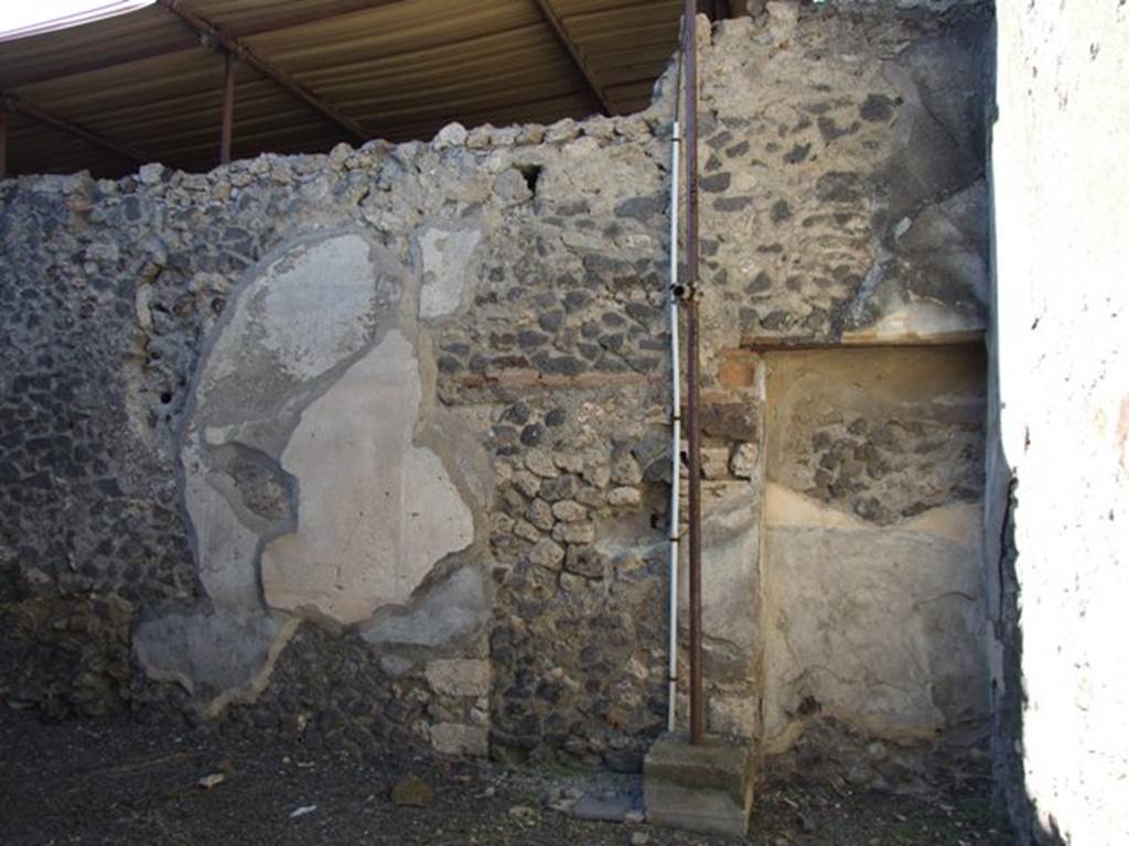 IX.9.d Pompeii. March 2009. Room e, north wall of triclinium. According to NdS, the walls of the triclinium were painted with yellow panels bordered by purple lines; White painted pilasters were placed between the panels, which reached to the yellow frieze divided by painted bosses; Below the frieze ran bands of purple, green and yellow. The floor of the triclinium was of crushed brick (mattone pesto), and in the north wall was a cupboard recess. See Notizie degli Scavi, 1889, p.131.