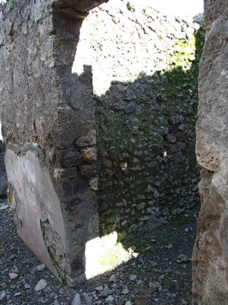 IX.9.e Pompeii. March 2009. Room 19, doorway to rustic room or cubiculum.
According to NdS, on the right wall of the entrance corridor, next to the doorway to the rustic room, graffiti was found on the red plastered zoccolo. It read
P-AE
This most probably referred to P. Ae(milius) for the number of times that this name occurred on the walls of this small roadway.
See Notizie degli Scavi, 1891, p.255.
