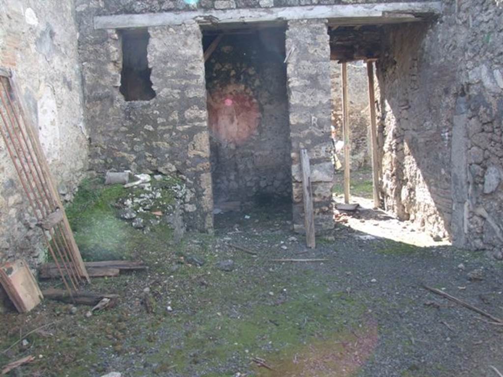 IX.9.f Pompeii. March 2009. Looking west across atrium to doorway to cubiculum, and entrance. According to NdS, near to the entrance corridor was a doorway to a cubiculum with the usual bed recess and with a window overlooking the atrium. Perhaps in the later years it was not a cubiculum, as its walls showed the remains of rustic plaster. So this cubiculum and the entrance corridor were covered with a loft or attic, which jutted out onto the vicolo with a balcony, which was preserved in part. The balcony was reached by a small staircase situated in the south-west corner of the atrium. The first step was of masonry and the rest of wood, concealing in part the entrance to the cubiculum. 
See Notizie degli Scavi, 1891, p.264
