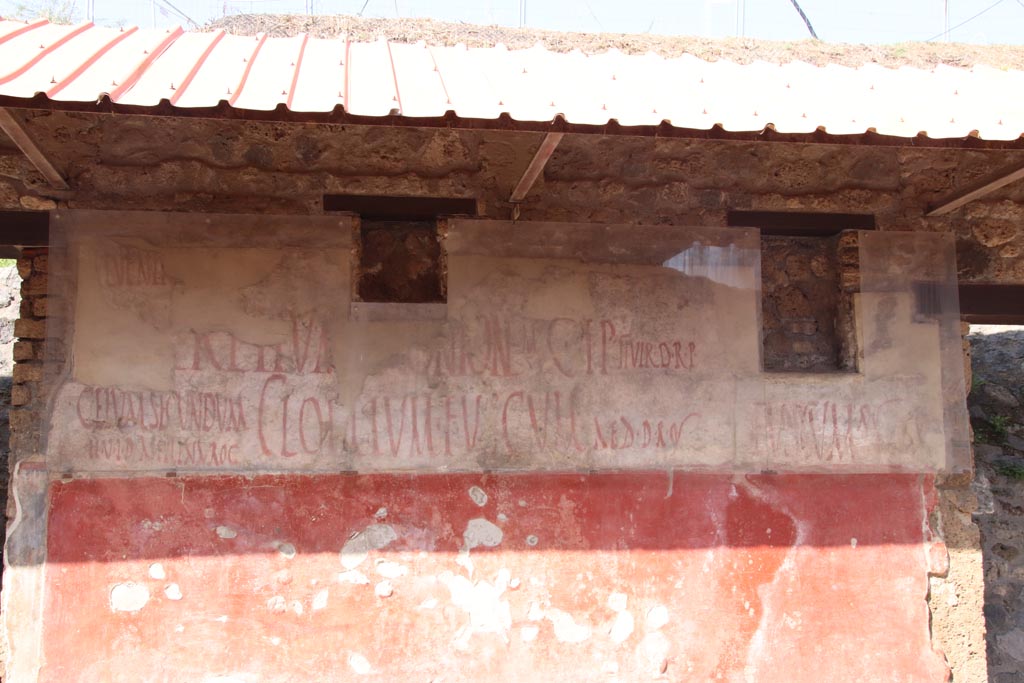 IX.11.3 Pompeii, on left, and IX.11.4, on right. October 2023. Graffiti between entrance doorways. Photo courtesy of Klaus Heese.