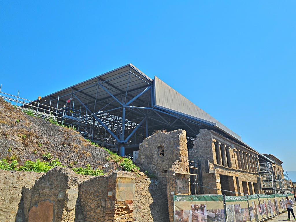 Via dell’Abbondanza, Pompeii. June 2024. 
Looking east along north side with IX.11.6/7/8 on left, IX.12, on right. Photo courtesy of Giuseppe Ciaramella.
