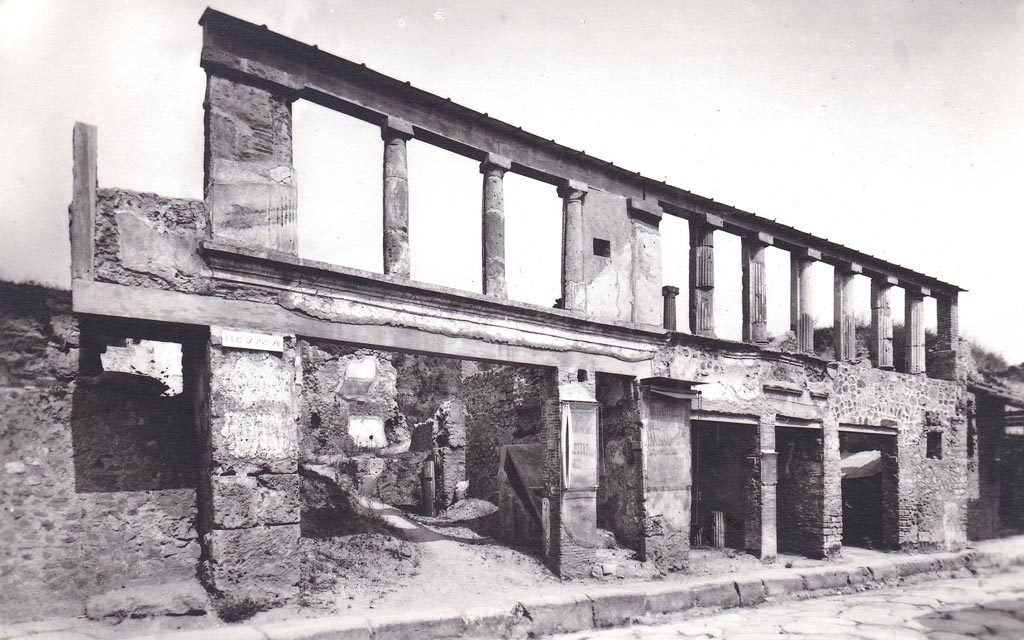 IX.12.1 Pompeii, centre left. Undated photographic postcard. 
Looking north across Via dell’Abbondanza, with unnamed Vicolo, on left below balcony, IX.12.1, IX.12.2, IX.12.3, IX.12.4, and  IX.12.5 on right.
Photo courtesy of Espen B. Andersson
