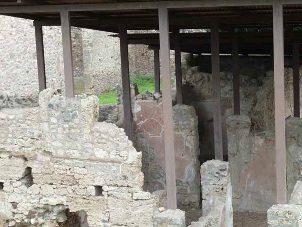 IX.14.c Pompeii. May 2010. Looking east across atrium (room 2), to doorway to room 6 in the north-east corner of the atrium. According to Spano in NdS,  straight ahead and to the left of the entrance were two rectangular decorations on white backgrounds of which nothing much remained, except a garland that formed the cornice above the one on the right. Spano surmised that perhaps the subject of these paintings may have been religious as garlands were found above the many lararium paintings in Pompeii. Found on the same wall was part of a layer of fine plaster, which had covered the previous decoration below it.
See Notizie degli Scavi, 1911, (p.374).