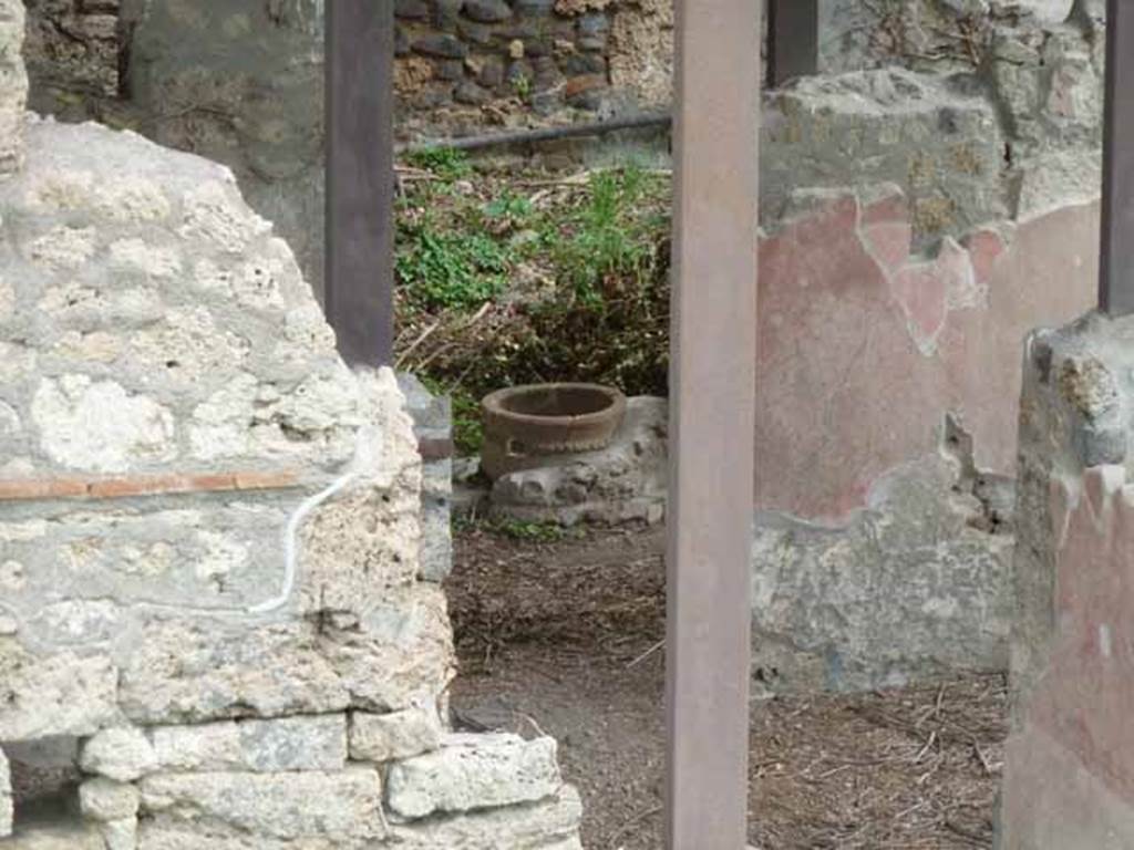 IX.14.c Pompeii. May 2010. Looking east through the entrance corridor to atrium, and through to portico 9 and garden area 3. A terracotta puteal (c) can be seen, standing on a masonry circle, in the doorway leading into the garden. See Jashemski, W. F., 1993. The Gardens of Pompeii, Volume II: Appendices. New York: Caratzas. (p. 252). According to Spano, the doorway to the garden area, 3, was at the right end of the east wall of the atrium. Through the doorway, one entered into a sort of portico with unadorned walls and earth floor, room 9. At the extreme left end of the east wall, the wall was decorated with a black plinth showing some painted plants, and decorated with a red wall. At the right end, to the south, there was a large cupboard, numbered 10, with white walls. This room received light by a high window in the east wall.