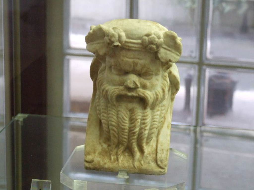 Marble head of Bacchus or Dionysus found in niche L in Villa Regina Boscoreale. December 2006. 
He is shown with a beard and adorned with a crown of ivy and flowers. 
Now in Boscoreale Antiquarium, inventory number 25828.
