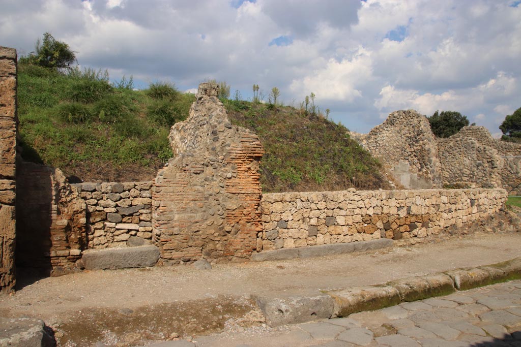 Via dell’Abbondanza, north side. October 2022. 
Continuation from photo above –
Entrance doorway to III.7.4, with grey lava doorway threshold, on left, another grey lava doorway threshold belonging to III.7.5, centre right.  
Photo courtesy of Klaus Heese
