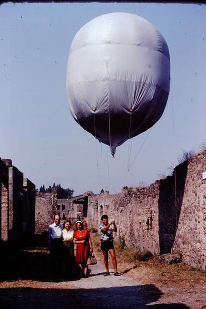 Via di Castricio, Pompeii. 1974. Looking west towards Stanley, Wilhelmina, Prof. Cerulli-Irelli and the “balloon”.  Photo by Stanley A. Jashemski.   
Source: The Wilhelmina and Stanley A. Jashemski archive in the University of Maryland Library, Special Collections (See collection page) and made available under the Creative Commons Attribution-Non Commercial License v.4. See Licence and use details. J74f0496
