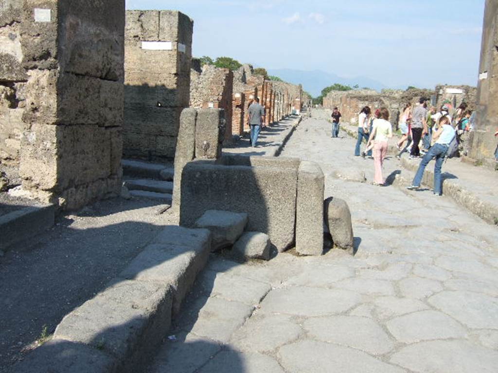 Via della Fortuna. North side.  Looking east with Vicolo dei Vettii on left behind fountain.  The crowd on the right is going into Vicolo Storto. May 2006.
