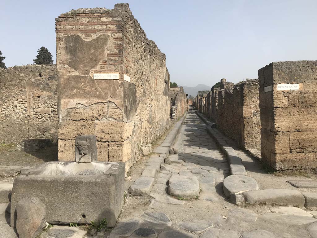 Vicolo dei Vettii between VI.13 and VI.14. April 2019. Looking north from Via della Fortuna. 
The fountain is outside VI.13.7. Photo courtesy of Rick Bauer.
