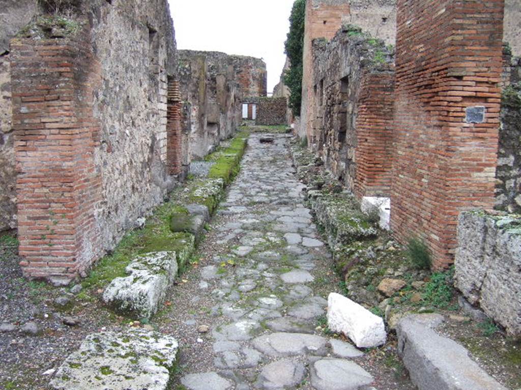 Vicolo del Balcone Pensile between both sides of VII.9. Looking west from crossroads with Vicolo di Eumachia between VII.9.54 and VII.9.37. December 2005.